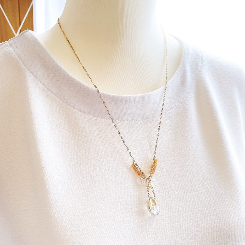 首元で涼しげに揺れるネックレス