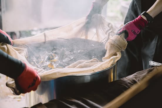 釜で蒸されている茶葉
